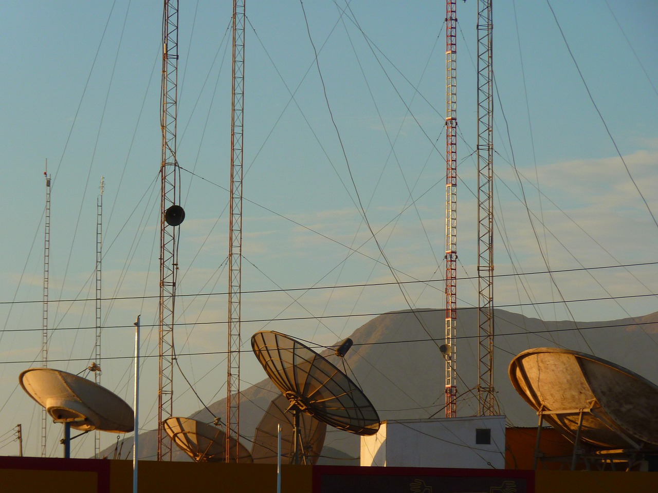 Satellite dish array on a rooftop — comparing traditional satellite TV versus IPTV internet streaming